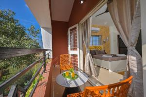 een balkon met een tafel en stoelen en een bed bij ll EMPYREAN STAY ll AIRAWAT VILLA ll 2BHK llAC ll PRIVATE POOL ll LUXE ll in Lonavala