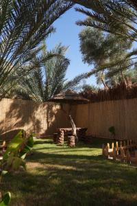 a backyard with a fence and a tree at Aviary AlUla 3 in Al-ʿUla +6 photos