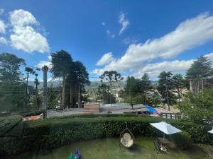 a view of a park with a table and an umbrella at Vila de Charme Suítes in Campos do Jordão