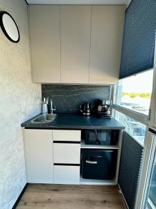 a kitchen with white cabinets and a sink at Видова смарт-квартира в ЖК City Park in Cherkasy