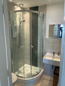 a bathroom with a glass shower and a sink at Seaside-Retreat in Largs +3 photos