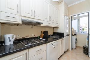 Una cocina con gabinetes blancos y un horno de estufa. en ZEN, WIFI FIBRE, NETFLIX, CENTRE, PLAGE, TANGERBNB com, en El Balia