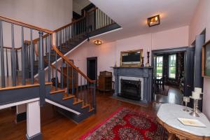 a living room with a staircase and a fireplace at Old Furnace Inn in Harrisonburg