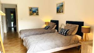 ein Schlafzimmer mit zwei Betten in einem Zimmer in der Unterkunft Les Soleiades in La Londe-les-Maures