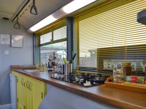 een keuken met een aanrecht met een wastafel en een raam bij Daisy Decker - Uk48371 in Hollym +14 foto's