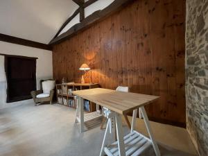 een kamer met een houten muur met een tafel en een stoel bij Le clos gaxen in Labastide-Clairence