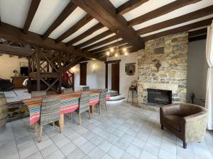 een woonkamer met een tafel en stoelen en een stenen open haard bij Le clos gaxen in Labastide-Clairence