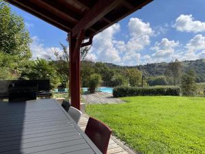 een terras met een tafel en stoelen in een tuin bij Le clos gaxen in Labastide-Clairence