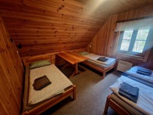 a room with two beds in a log cabin at Chalupa Pod lomem - Malá in Dolní Morava +11 photos