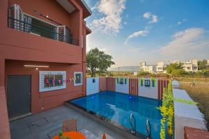 een huis met een zwembad naast een gebouw bij ll EMPYREAN STAY ll AIRAWAT VILLA ll 2BHK llAC ll PRIVATE POOL ll LUXE ll in Lonavala