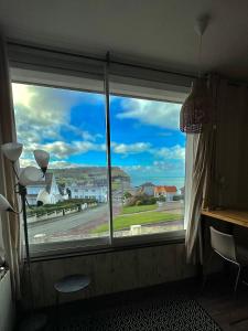 a window in a room with a view of a street at La Perle Marine superbe vue mer terrasse 30m2 in Criel-sur-Mer