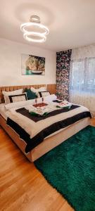 a large bed in a bedroom with a green rug at Mony Apartaments in Roman