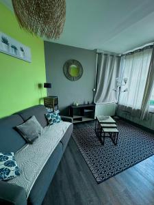 a living room with a couch and a table at La Perle Marine superbe vue mer terrasse 30m2 in Criel-sur-Mer