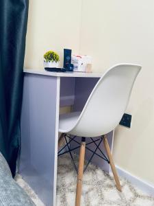 a white chair sitting next to a desk at Winnie's home in Athi River +5 photos