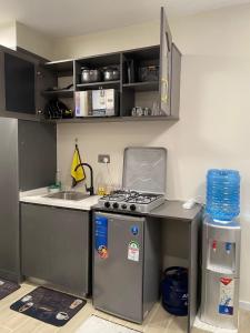 a small kitchen with a stove and a sink at Winnie's home in Athi River