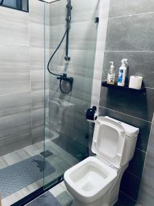 a bathroom with a toilet and a glass shower at Winnie's home in Athi River