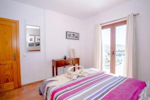 Un dormitorio blanco con una cama con ventana. en 3 bedroom villa with pool and jacuzzi, en Playa Blanca 44 fotos más