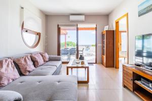 Una sala de estar con un sofá y un televisor. en 3 bedroom villa with pool and jacuzzi, en Playa Blanca