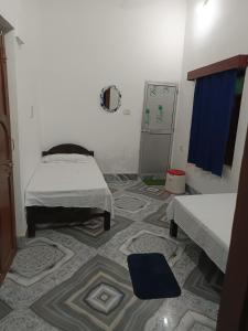 a room with two beds and a blue curtain at Shahi House in Bodh Gaya