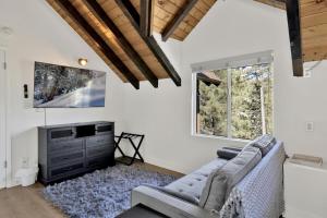 ein Wohnzimmer mit Sofa und Fernseher in der Unterkunft Round Rock Lodge at Big Bear Boulder Bay Modern Retreat w/ Pool Table Minutes to Activities in Big Bear Lake