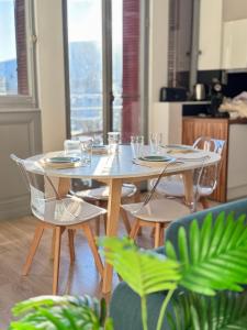 a table and chairs with glasses and plates on it at Le Bernascon - Mezzanine et Calme in Aix-les-Bains