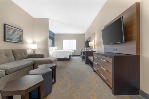 a living room with a couch and a flat screen tv at Best Western Plus Isanti in Isanti