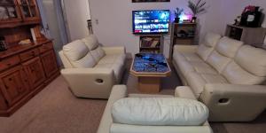a living room with white couches and a tv at Ganze 95qm Wohnung mit 4 Schlafzimmern, privater Komfort Küche, Bad, WC und Wohnzimmer, mit Gratis Frühstück und Parkplatz, mit Garten, so privat wie zu Hause in Kassel