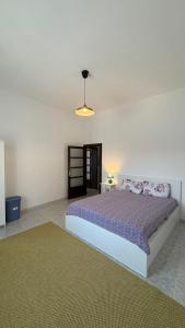 une chambre avec un lit avec une couette violette dans l'établissement Villa Pietra Sardinia - Luxury 165 m2 Historic Stone House with Fireplace and Rooftop, à Tempio Pausania