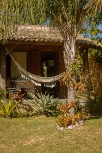 インビトゥバにあるCasa Florestaのハンモックが前に置かれた家