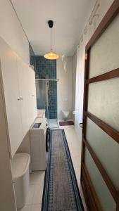 une salle de bain avec un lavabo et des toilettes et une porte dans l'établissement Villa Pietra Sardinia - Luxury 165 m2 Historic Stone House with Fireplace and Rooftop, à Tempio Pausania