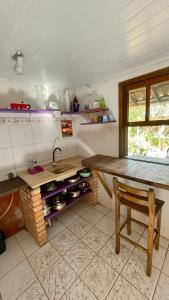a kitchen with a wooden table and a sink at Casa Floresta in Imbituba +47 photos