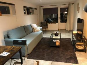 a living room with a couch and a table at Gastensuite Eindhoven B&B Flora in Eindhoven