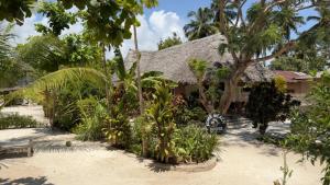 una casa con alberi e piante di fronte ad essa di Kome apartment two a Jambiani
