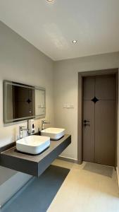 a bathroom with two sinks and a large mirror at Dune View Luxury Villas in Ḩawīyah