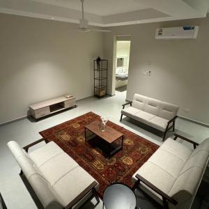 a living room with two couches and a coffee table at Dune View Luxury Villas in Ḩawīyah