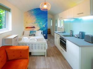 eine Küche mit einer Couch und einem Tisch in einem Zimmer in der Unterkunft Woodpecker - Uk43451 in Hayle