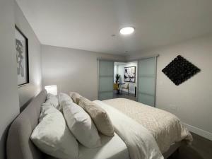 a bedroom with a white bed with pillows on it at Downtown bright & cozy 1 BR with 6 appliances in Halifax