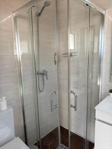 a shower with glass doors in a bathroom at Solmare Suites by Atlas in Albufeira