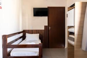 Habitación con cama y armario con TV. en Hospedagem Quinta do Correia, en Penha