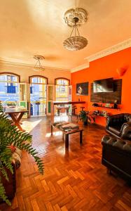 un salon avec des murs orange et un canapé et une table dans l'établissement Varanda Pouso e Arte, à Ouro Preto