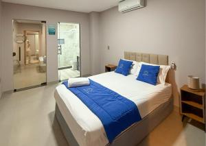 a bedroom with a large bed with blue pillows at Luxo Frente Mar em 7 Qtos com Ar sendo 4 suites para até 18 pessoas, 2 Jacuzzi Aquecidas, piscina, brinquedoteca, 5min de Castelhanos in Anchieta