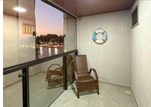 a balcony with a chair and a clock on the wall at Luxo Frente Mar em 7 Qtos com Ar sendo 4 suites para até 18 pessoas, 2 Jacuzzi Aquecidas, piscina, brinquedoteca, 5min de Castelhanos in Anchieta +54 photos