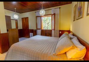 モンテ・ヴェルデにあるChalés Caminho das Pedrasのベッドルーム1室(枕付きのベッド1台、窓付)