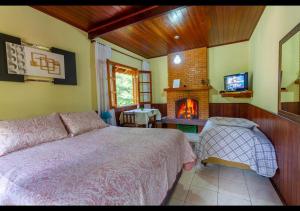 モンテ・ヴェルデにあるChalés Caminho das Pedrasのベッドと暖炉のある寝室