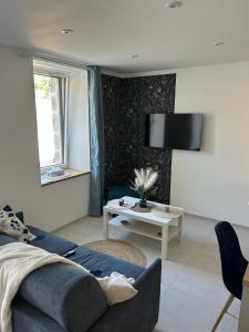 a living room with a blue couch and a table at Bleu horizon in Rosnoën