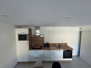 a small kitchen with a sink and a microwave at Bleu horizon in Rosnoën
