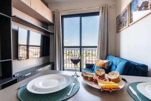 a table with a plate of bread and a glass of wine at Apto Novo Centro SP Com Vista Panorâmica in Sao Paulo