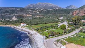 an aerial view of a beach with mountains in the background at LITHOS by the sea in Neon Oitilon