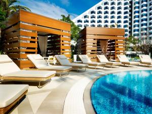 a hotel patio with lounge chairs and a pool at Crown Metropol Perth in Perth