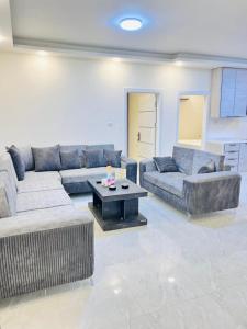 a living room with two couches and a coffee table at Zurich Furnished Apartments in Al Mafraq